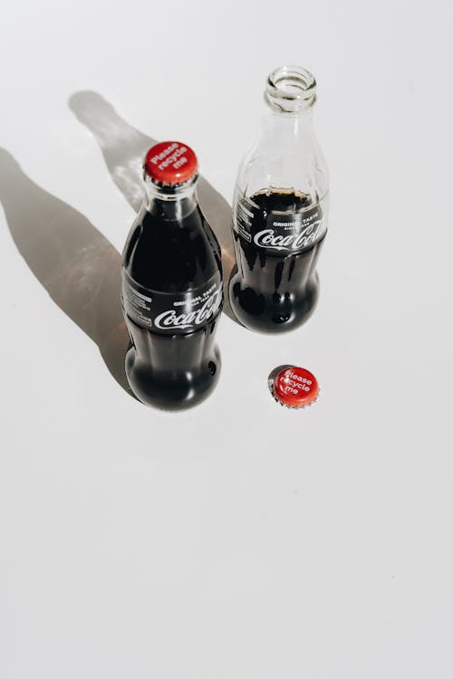 Free 2 Coca Cola Bottles on White Table Stock Photo