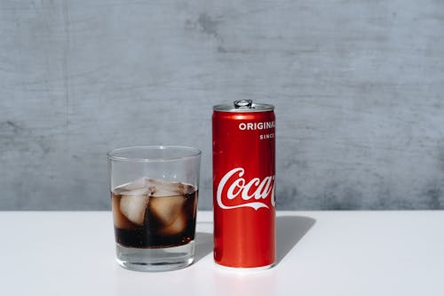 Free Coca Cola Can Beside Drinking Glass Stock Photo