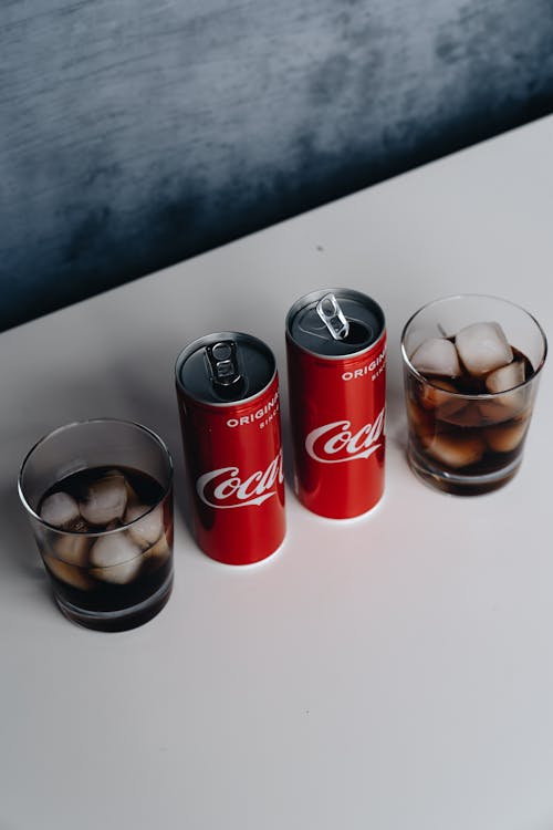 Free Photo Of Canned Soft Drinks Beside Glasses Stock Photo
