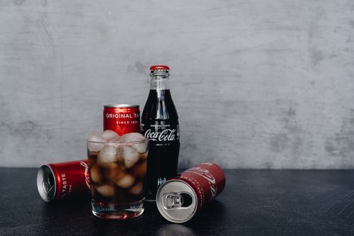 Free Chilled Coca-Cola bottles and cans with ice, offering a refreshing drink experience. Stock Photo