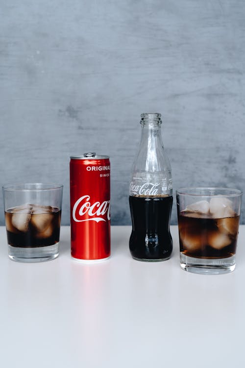 Free Photo Of Canned Soft Drinks Beside Glass Stock Photo