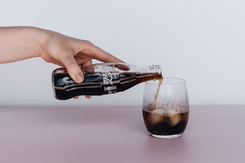 Free Photo Of Person Pouring Soft Drinks On Glass Stock Photo
