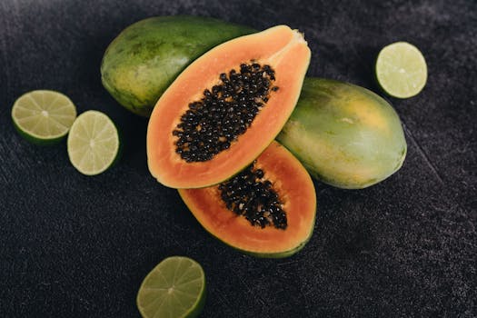 Sliced papaya and lime on a dark background, highlighting fresh tropical fruits in vivid detail.