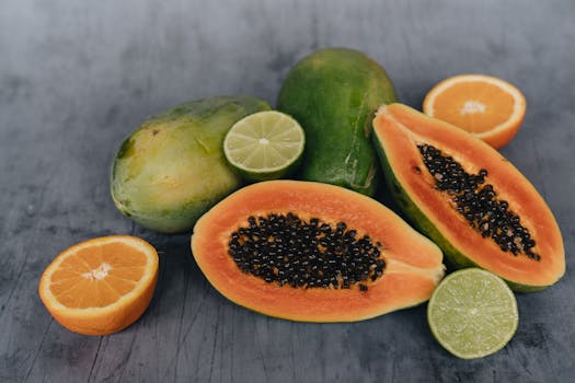 A vibrant assortment of sliced papaya, lime, and orange on a rustic surface.