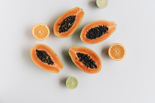 A vibrant flat lay of fresh papaya and citrus slices on a white background.