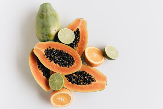 Top view of vibrant papaya, lime, and orange slices showcasing freshness