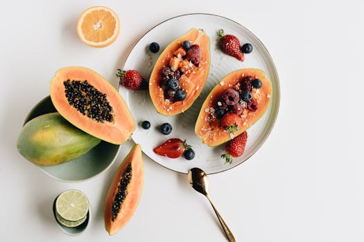 A vibrant plate of papaya filled with fresh berries and citrus slices for a nutritious meal.