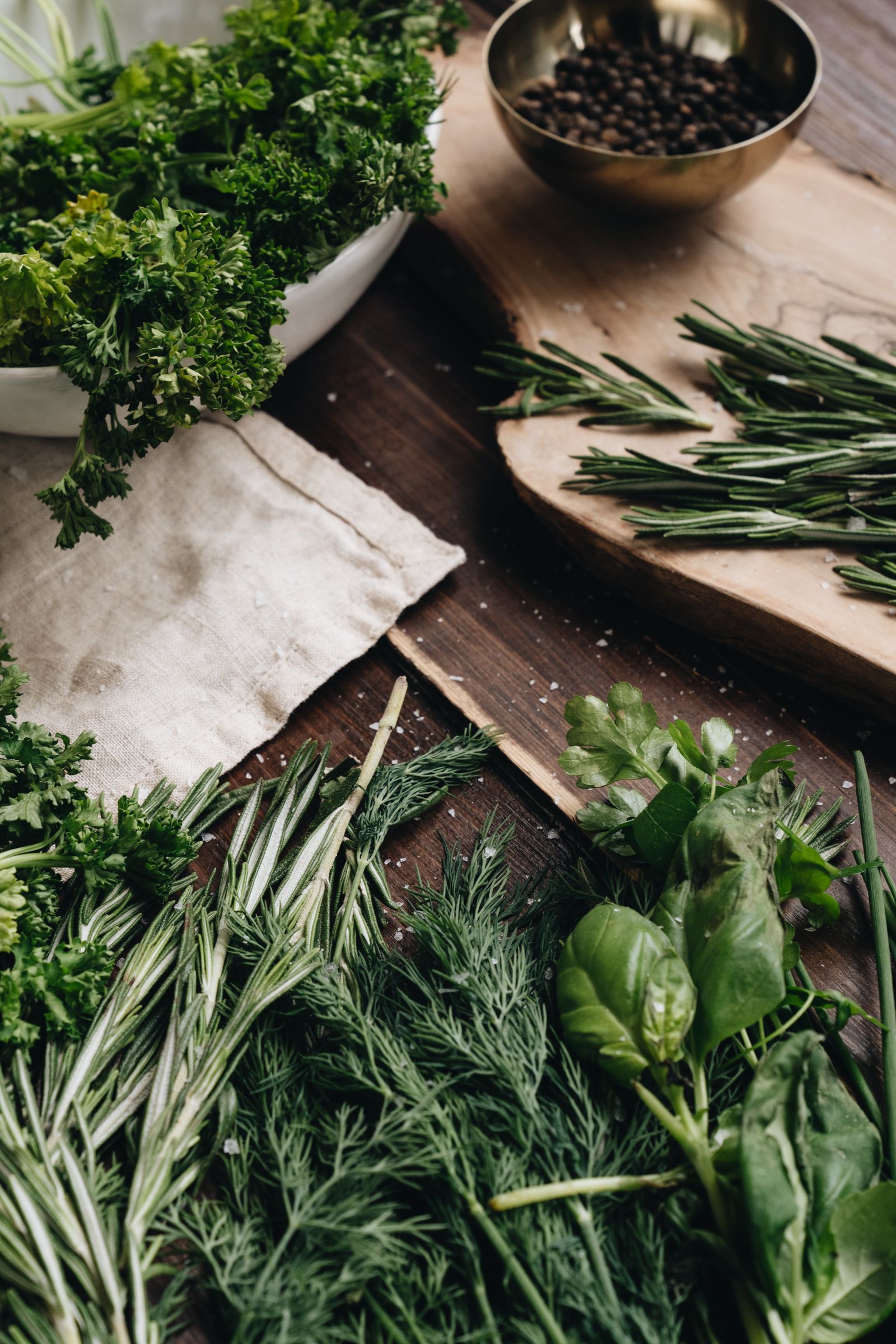 Fresh parsley, rosemary, dill and basil on a rustic wooden kitchen counter