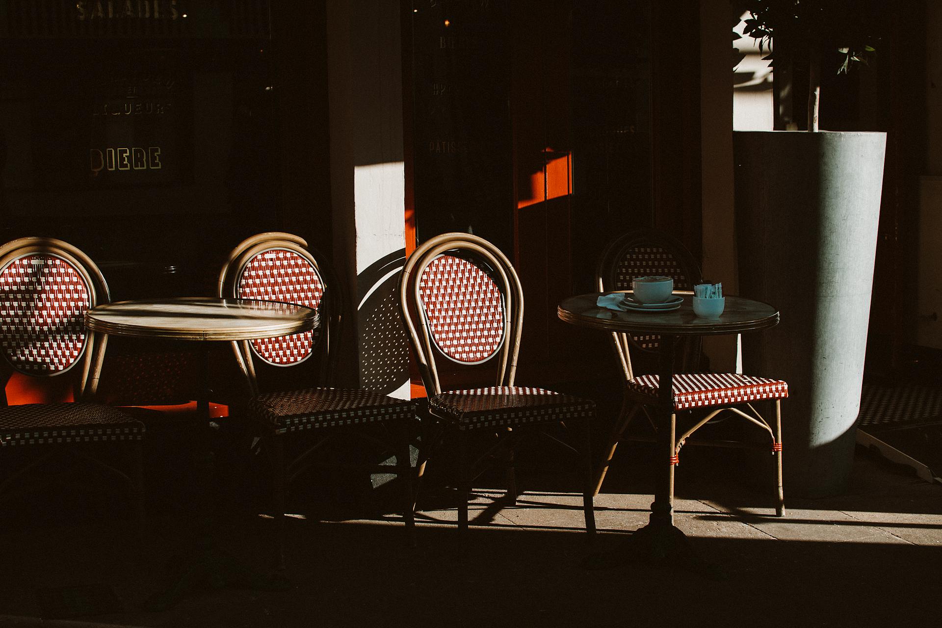 Charming outdoor cafe seating with wooden chairs and tables in the sunlight, Chester.