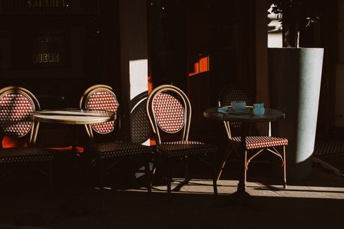 Free Charming outdoor cafe seating with wooden chairs and tables in the sunlight, Chester. Stock Photo