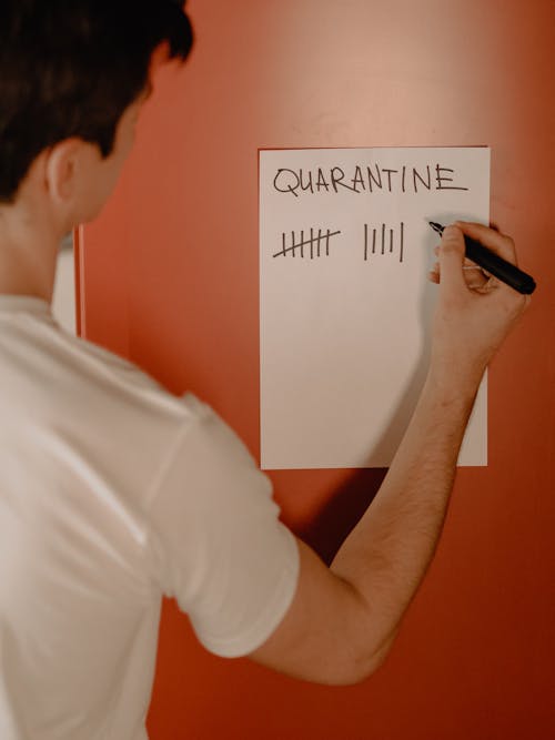 Man in White T-shirt Holding Black Smartphone