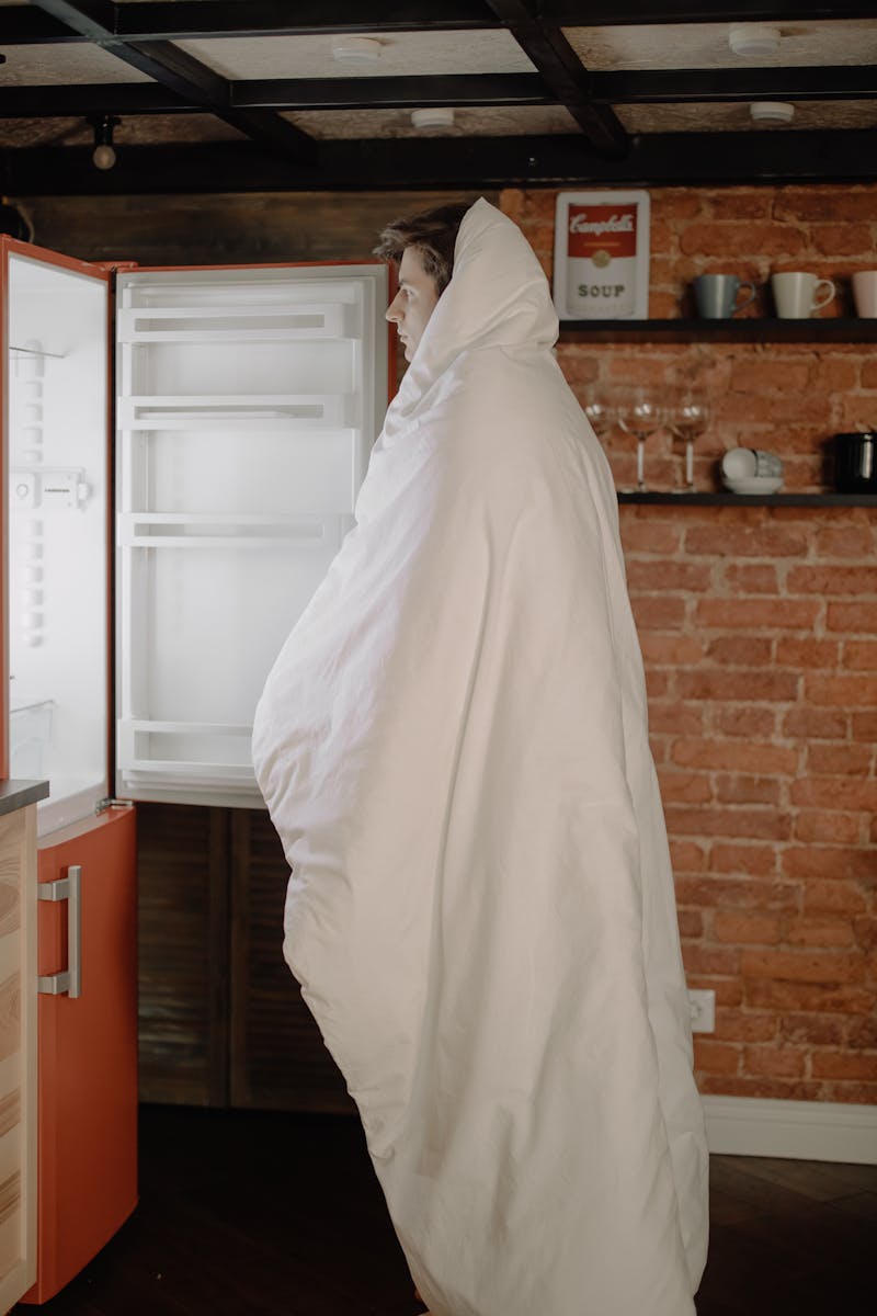 Woman in White Hijab Standing Near White Top Mount Refrigerator