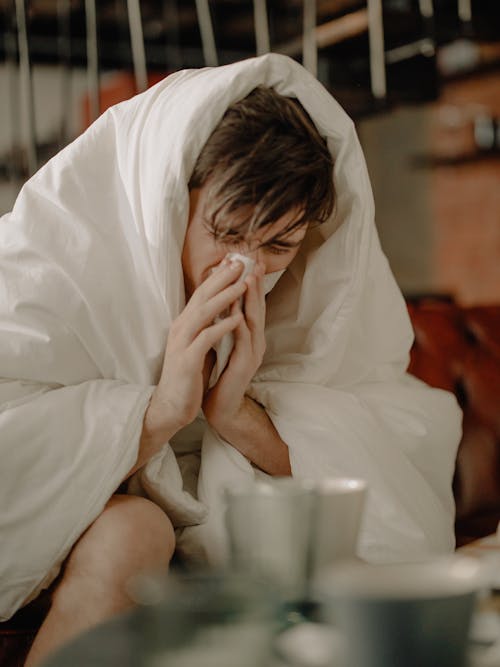 一個生病的人用紙巾擦鼻子