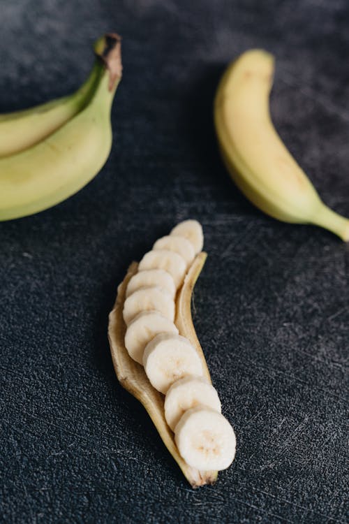 Ripe cut banana on black rough surface