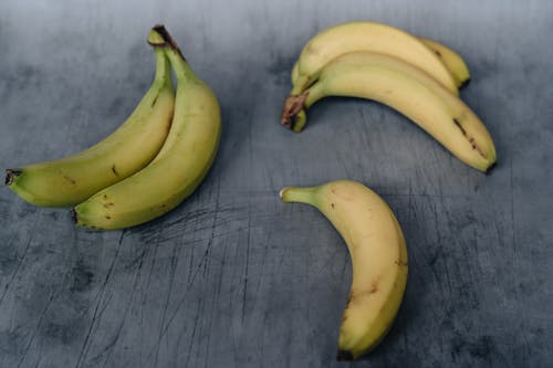 Free Unpeeled ripe bananas on shabby surface Stock Photo