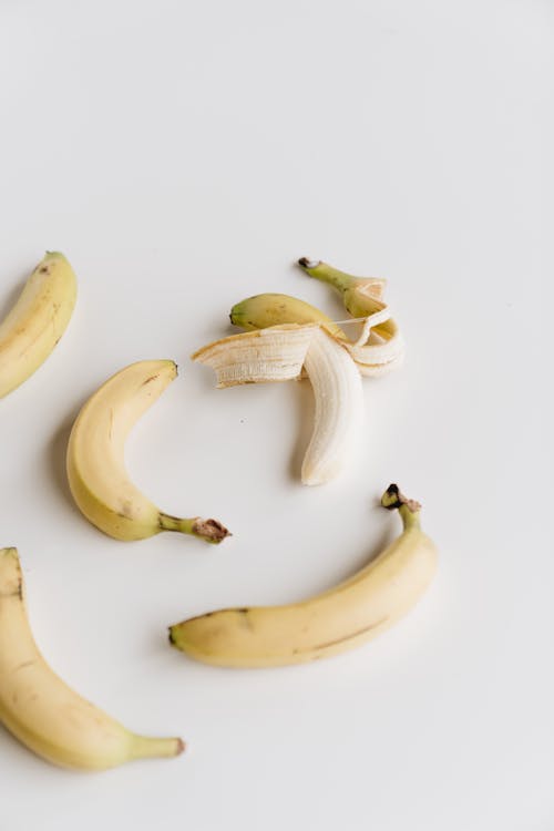 Ripe bananas on white surface