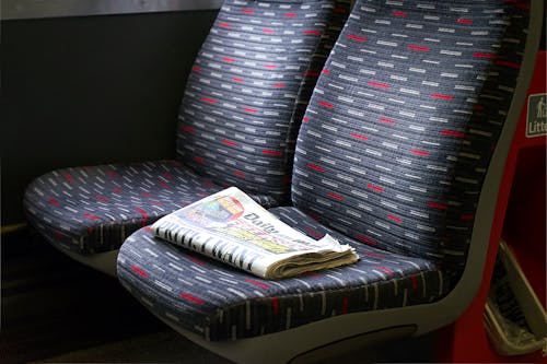 Free Bus Seat with Newspaper Stock Photo