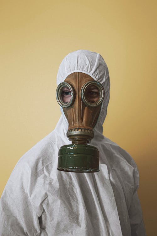 Person Wearing Gas Mask and White Protective Suit