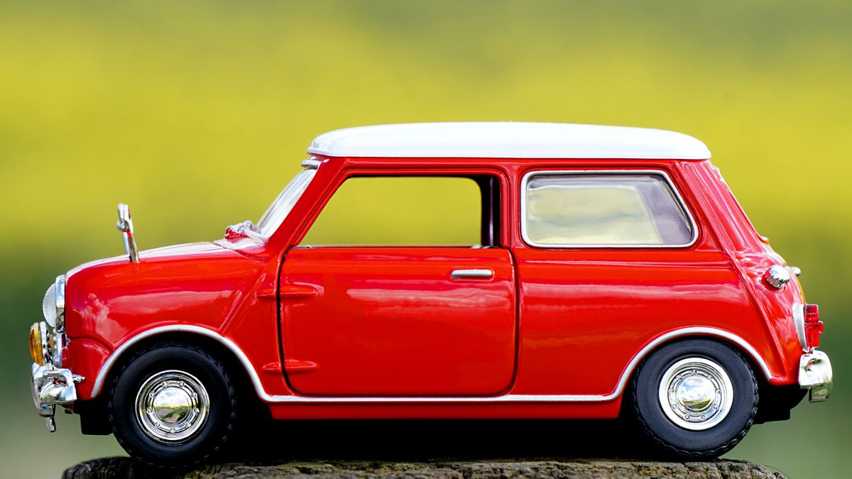 Miniatura de carro vermelho em uma superfície clara