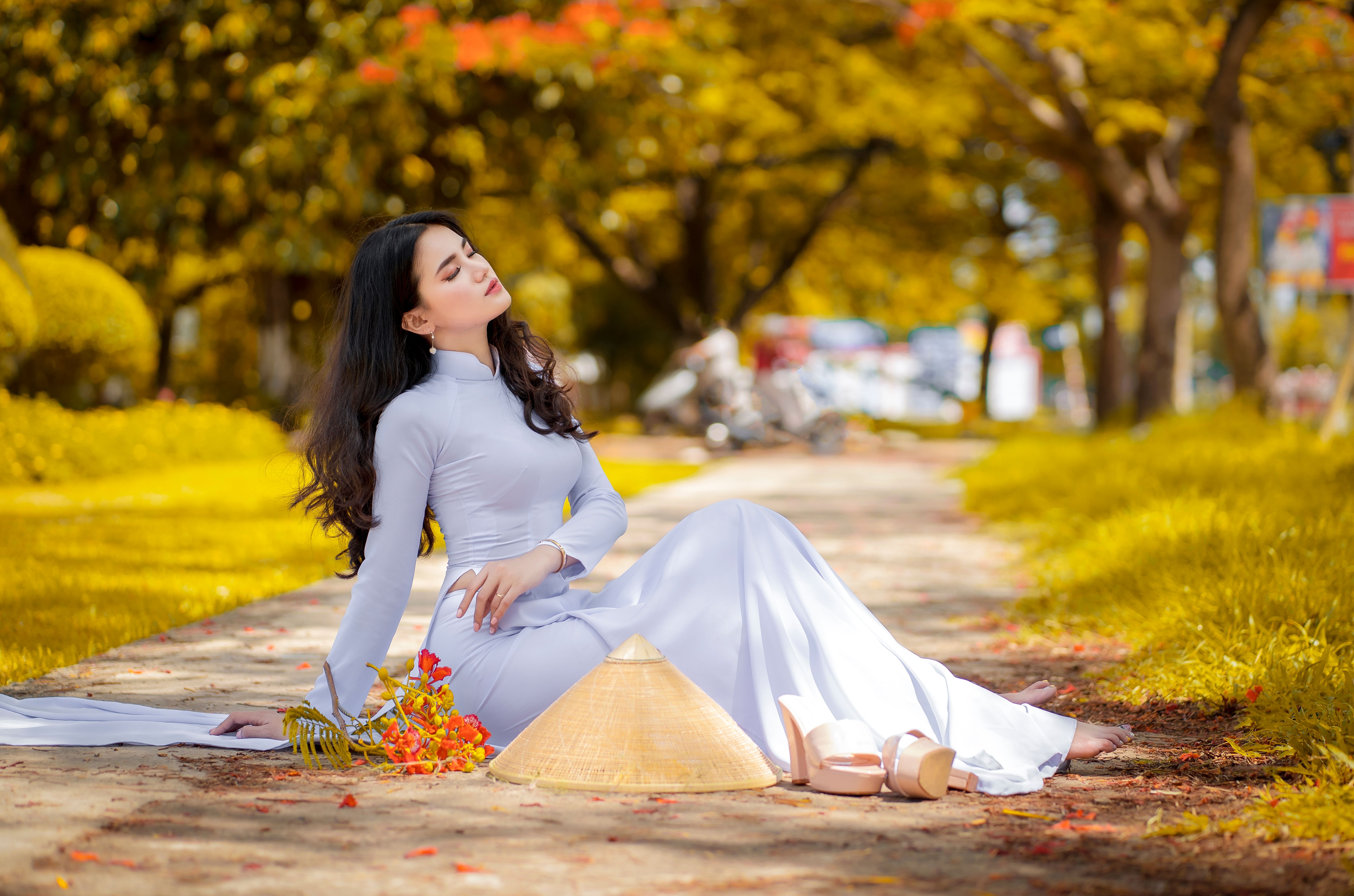 Woman in White Long Sleeve Dress Sitting On Paved Pathway · Free Stock ...