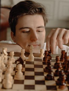 年轻人在舒适的家庭环境中思考国际象棋策略