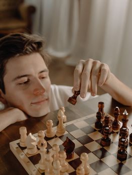 一位年轻人在家专注地进行国际象棋比赛，展现了战略与专注力