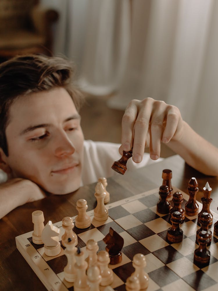 Woman Holding Chess Piece On Chess Board