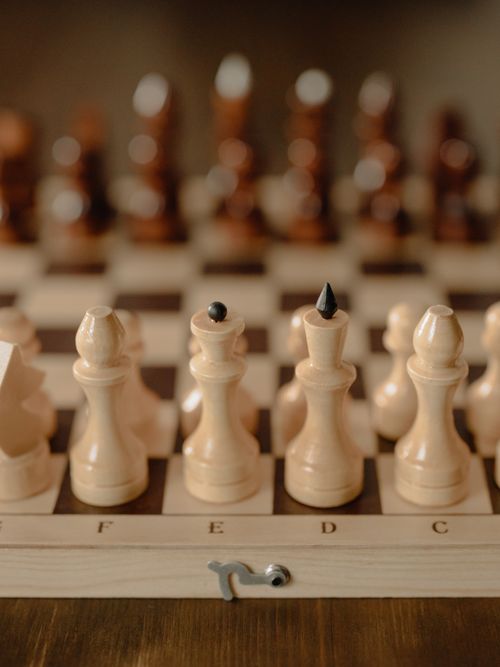 Free Close-up view of chess pieces on a classic wooden board, focusing on strategy and challenge. Stock Photo