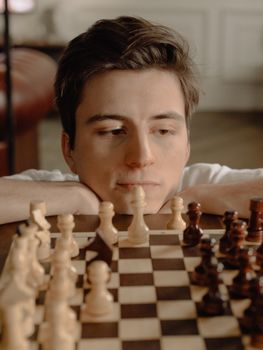 在舒适的家庭环境中，一个专注的人正在为他的下一步国际象棋走法制定策略