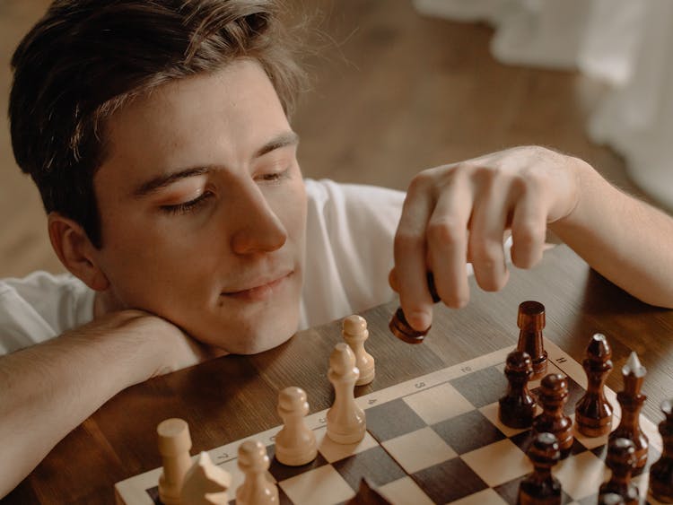 Woman Holding Brown Wooden Chess Piece