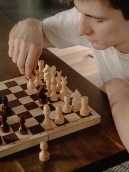 一个年轻人在舒适的家庭环境中专注于国际象棋的战略性对弈