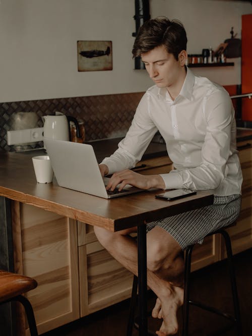 Mujer En Camisa De Vestir Blanca Sentada En Una Silla Con Macbook