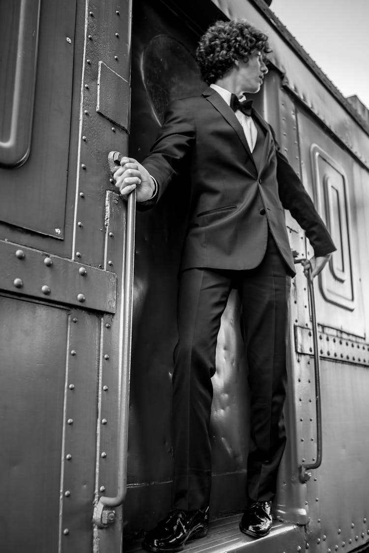 Grayscale Photography Of Man Riding Train