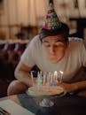 男人在家庆祝生日，吹灭了蛋糕上的蜡烛