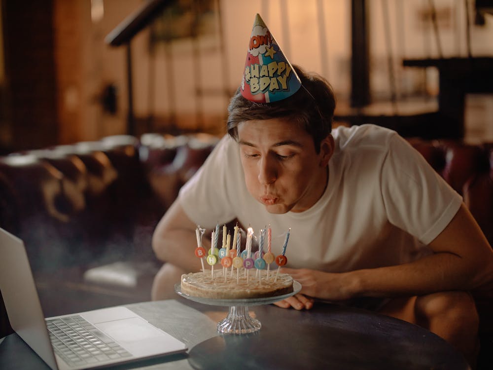Free Man in White Crew Neck T-shirt Sitting by the Table With Cake Stock Photo