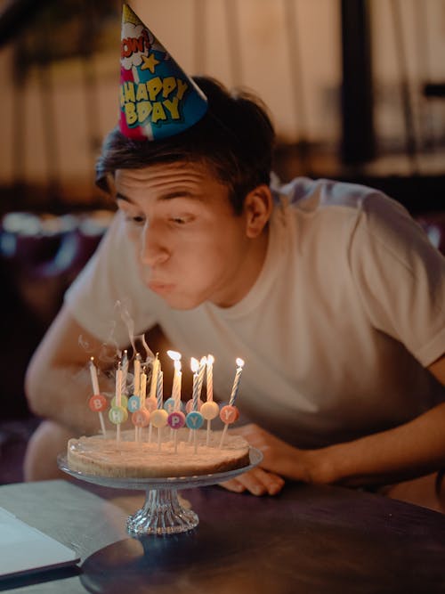 Free Boy in White Crew Neck T-shirt Blowing Candles on Cake Stock Photo