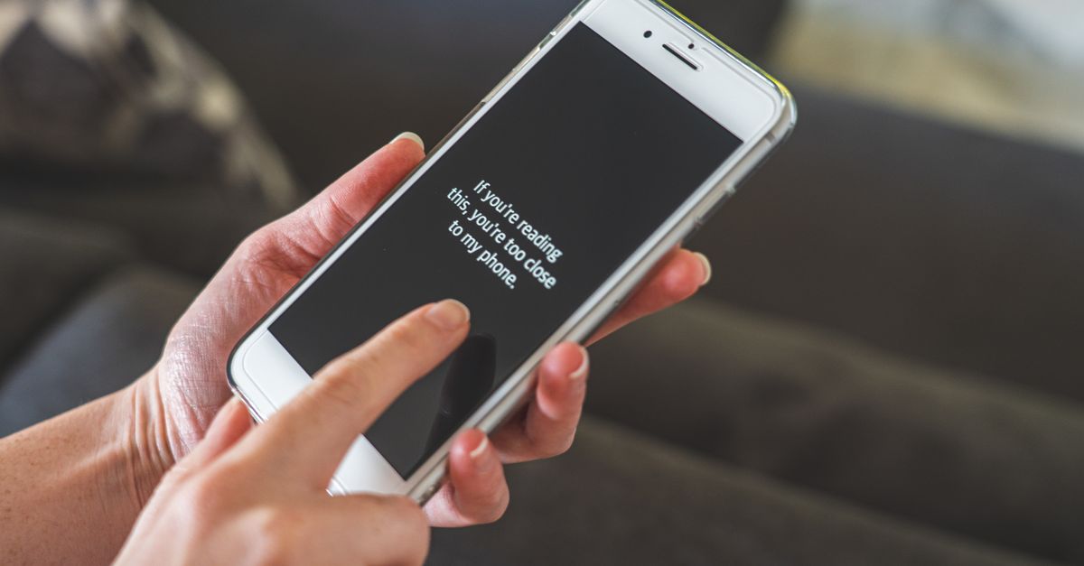 Person reading a property listing on a phone in a bright room