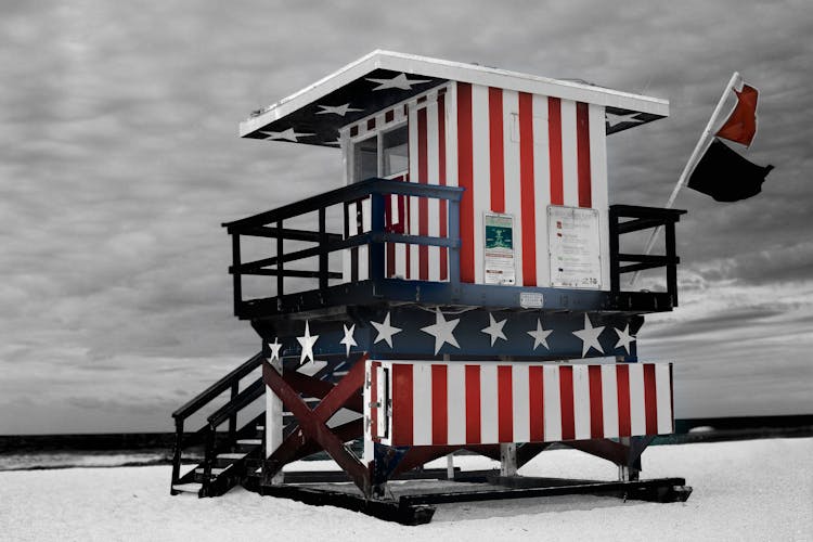 Red And Blue Striped Shed On Sand