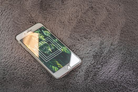 A smartphone displaying 'Life Is Now' on a cozy gray textured surface. Perfect for inspiration.
