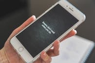 特写镜头中，一只手握着智能手机，屏幕上显示着励志名言：“除非付诸行动，否则梦想不会成真