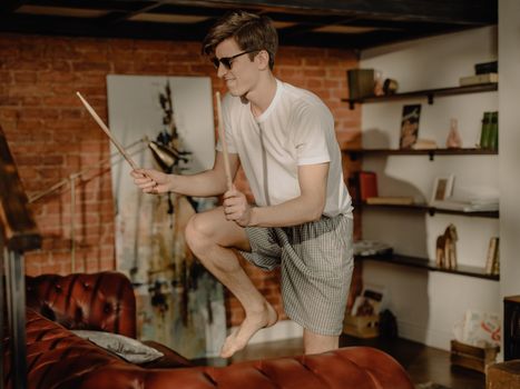 Man in White Crew Neck T-shirt and Gray and Black Checkered Shorts Holding Black Smartphone