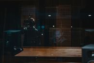 Faceless man in casual clothing taking video while male colleague working with equipment in recording studio