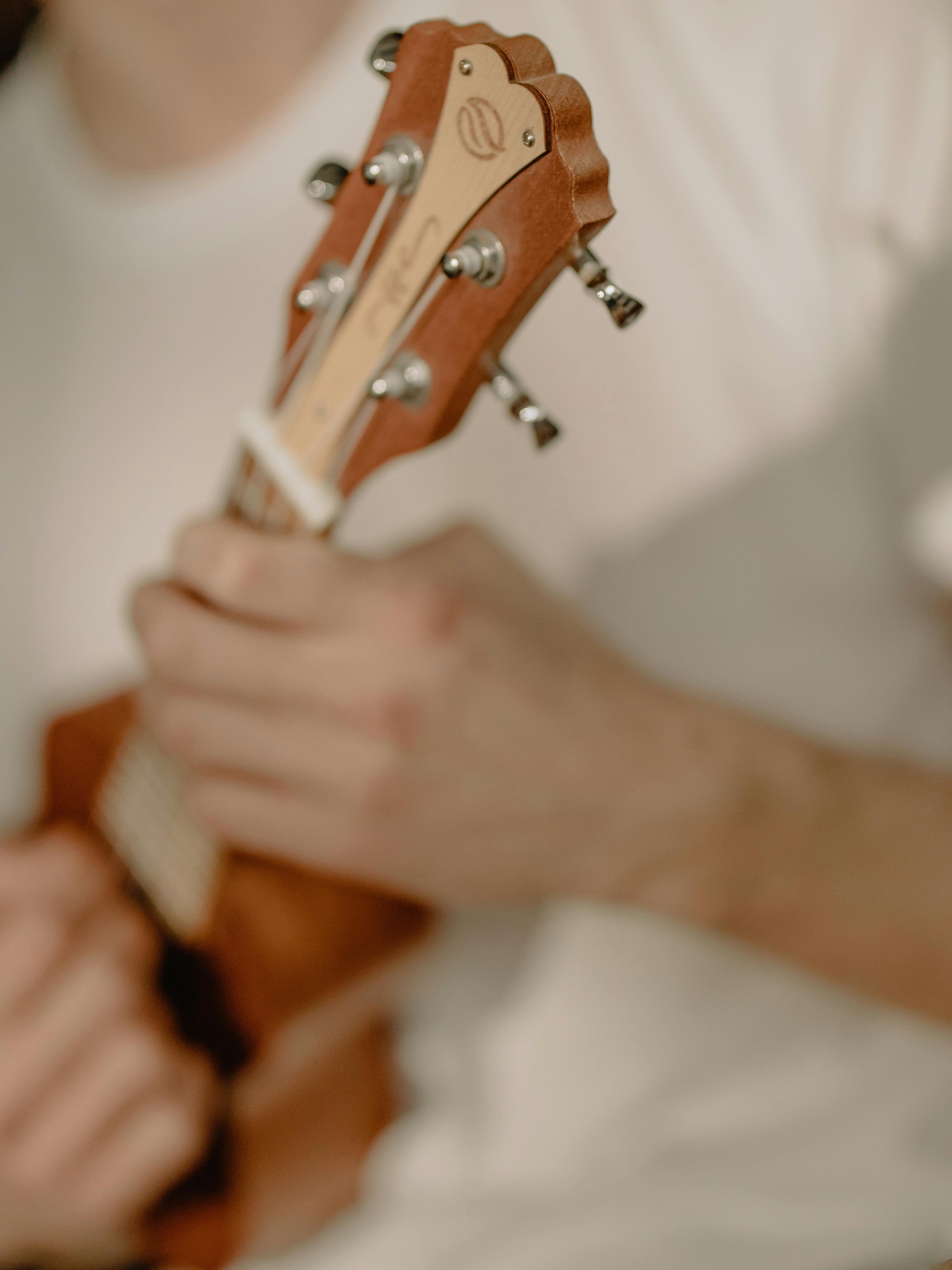 person playing brown wooden guitar