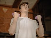 一个年轻人在休闲的家庭环境中举着哑铃锻炼