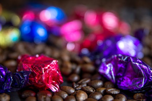 Detailed close-up of colorful wrapped candies resting on aromatic coffee beans.