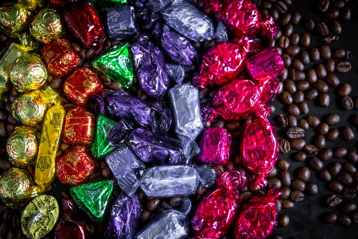 Vibrant assorted candies and coffee beans arranged in a decorative flat lay.
