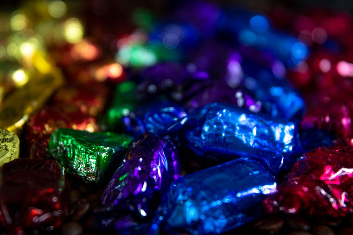 Close-up of colorful foil-wrapped candies with a vibrant bokeh effect, perfect for backgrounds.