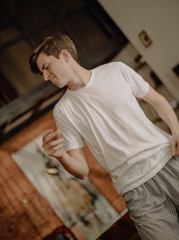 A young man in a cozy home setting, enjoying a moment of leisure in casual attire.