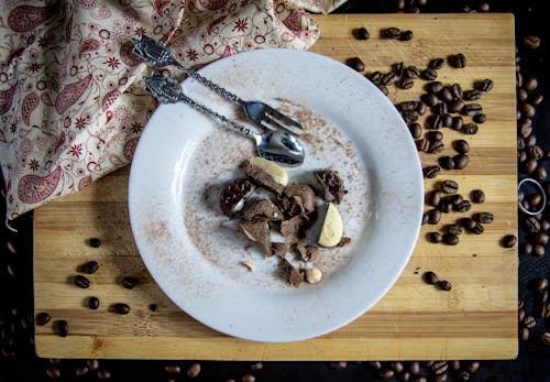 Chocolate Candy on Ceramic Plate Beside Coffee Beans on Wooden Board