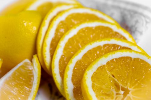Free Close-up of vibrant orange slices on a decorative plate, ideal for food photography. Stock Photo